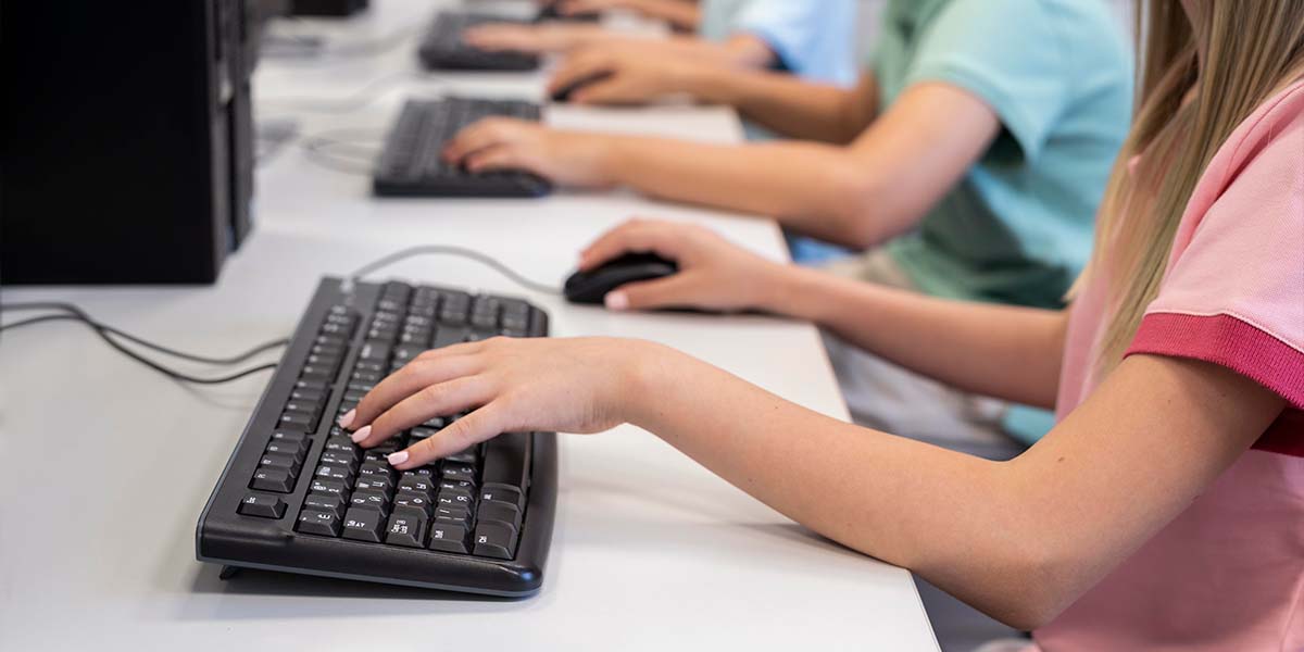 Adolescentes teclando em computadores enquanto estudam - site Colégio Equipe - Belém - Pará