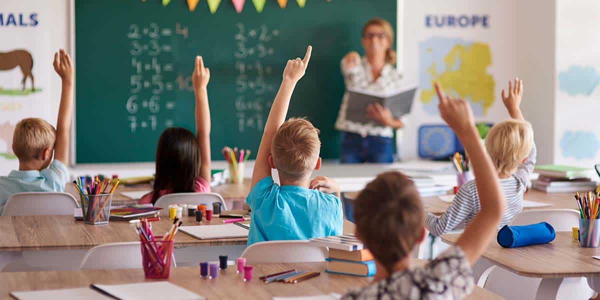 Garotos levantando as mãos em sala de aula para responder em sua escola particular - site Colégio Equipe - Belém - Pará